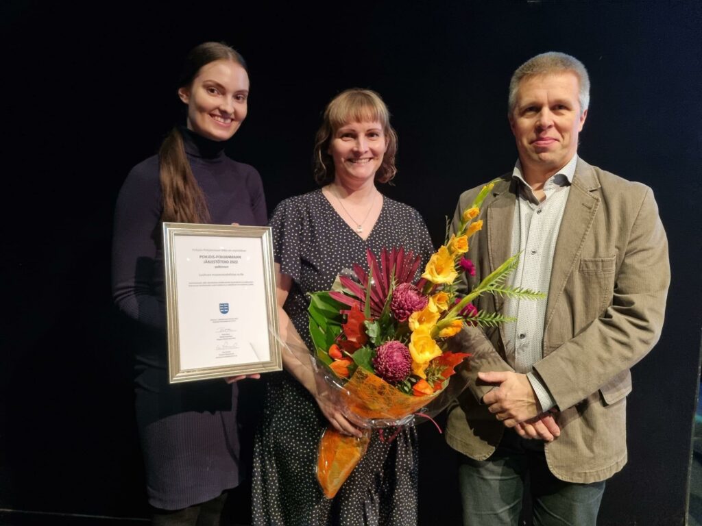Kuvassa vuoden 2022 Pohjois-Pohjanmaan järjestötekopalkinnon saaneen Luohuan maaseutuyhdistyksen edustajat palkintoadressin ja kukkien kanssa.